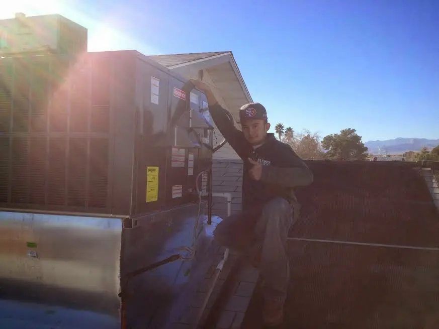 HVAC technician performing AC Tune-Up on a rooftop unit in Ellenton