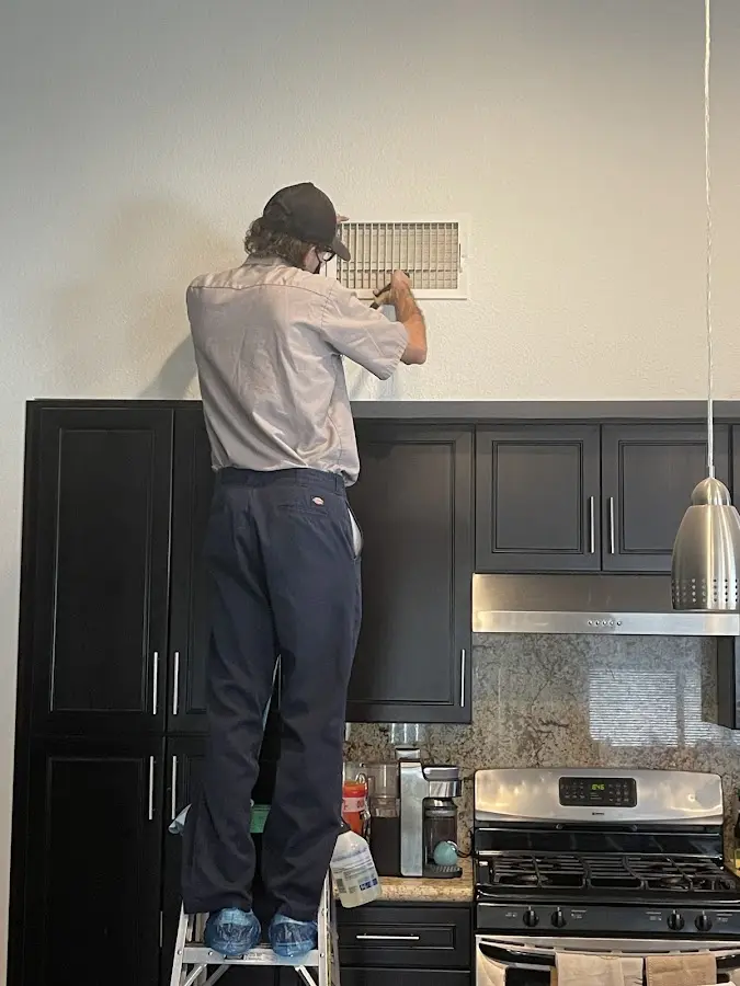 Technician inspecting an air vent during HVAC service in Ellenton